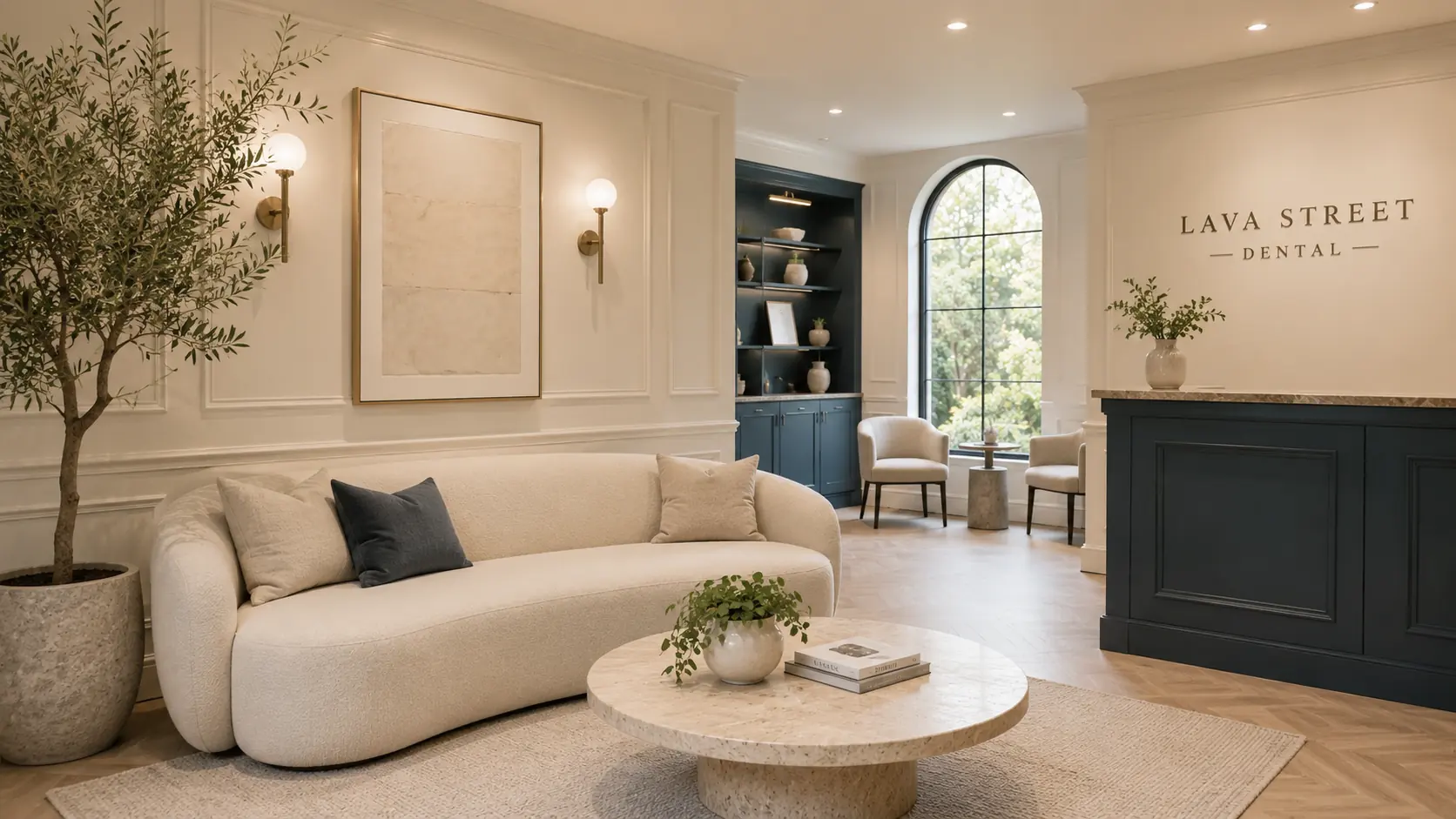 Reception and waiting area at Lava Street Dental: a curved bouclé sofa, olive tree and navy reception desk beneath the practice signage.